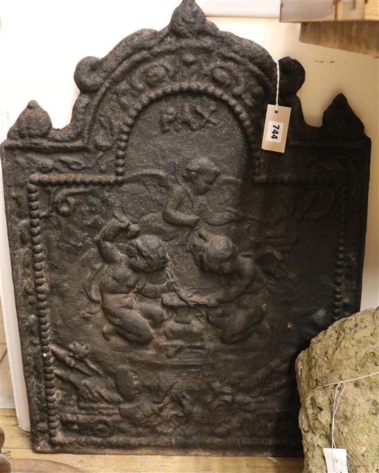 A cast iron fireback decorated with cherubs, bearing date 1679, W.58cm